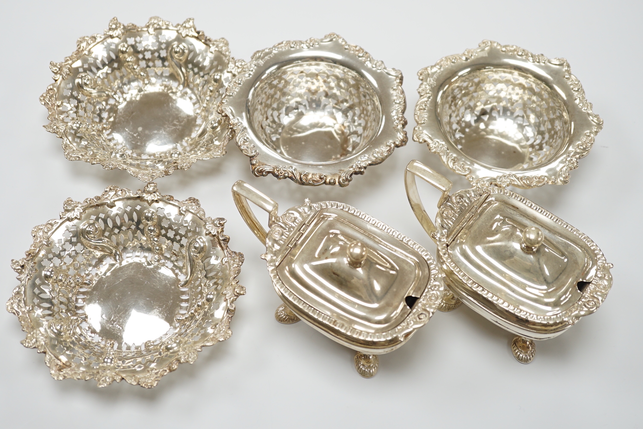 Two pairs of early 20th century pierced silver bonbon dishes, largest diameter 12.3cm and a pair of silver mustard pots.